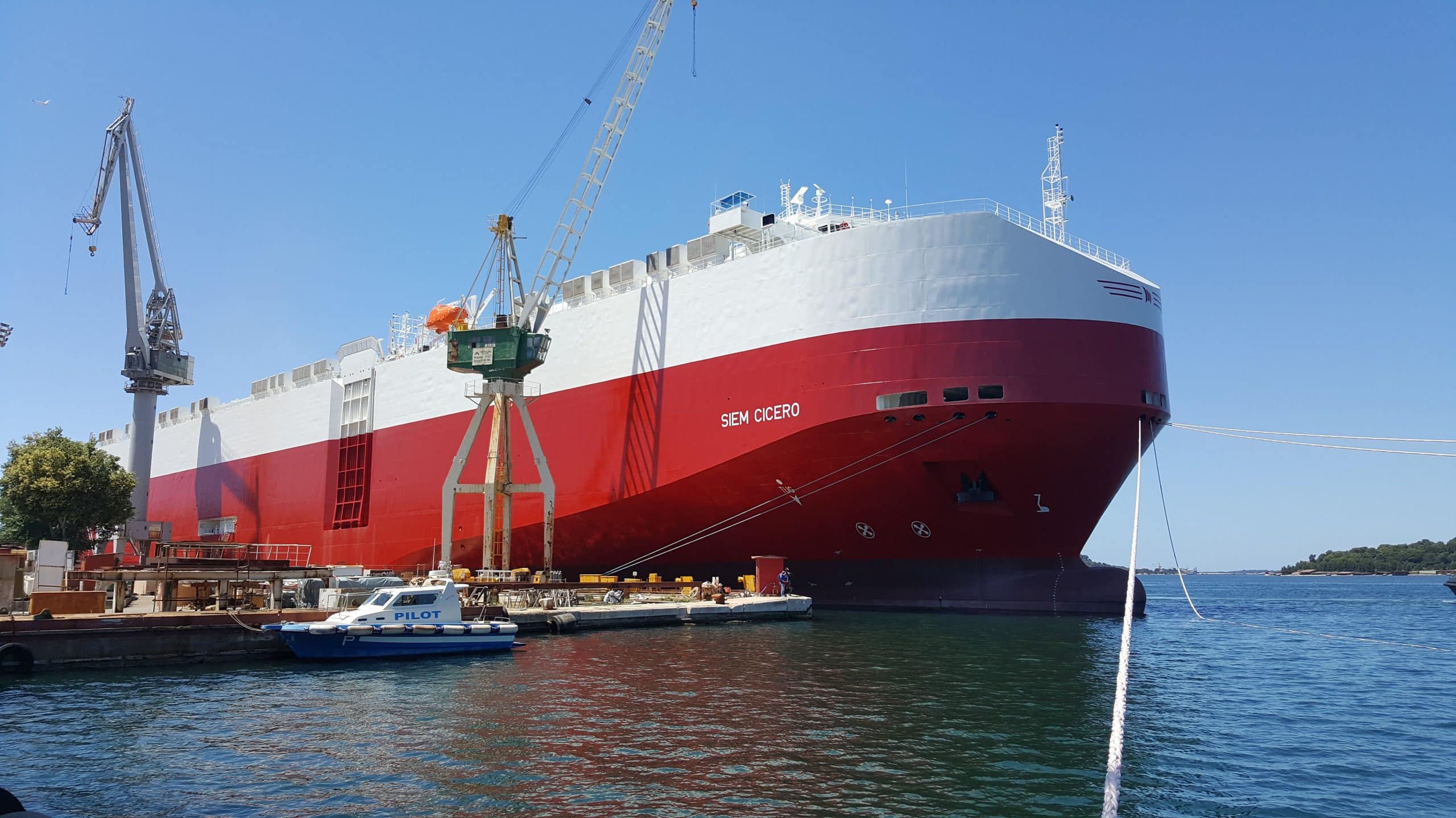 A large red and white ship docked