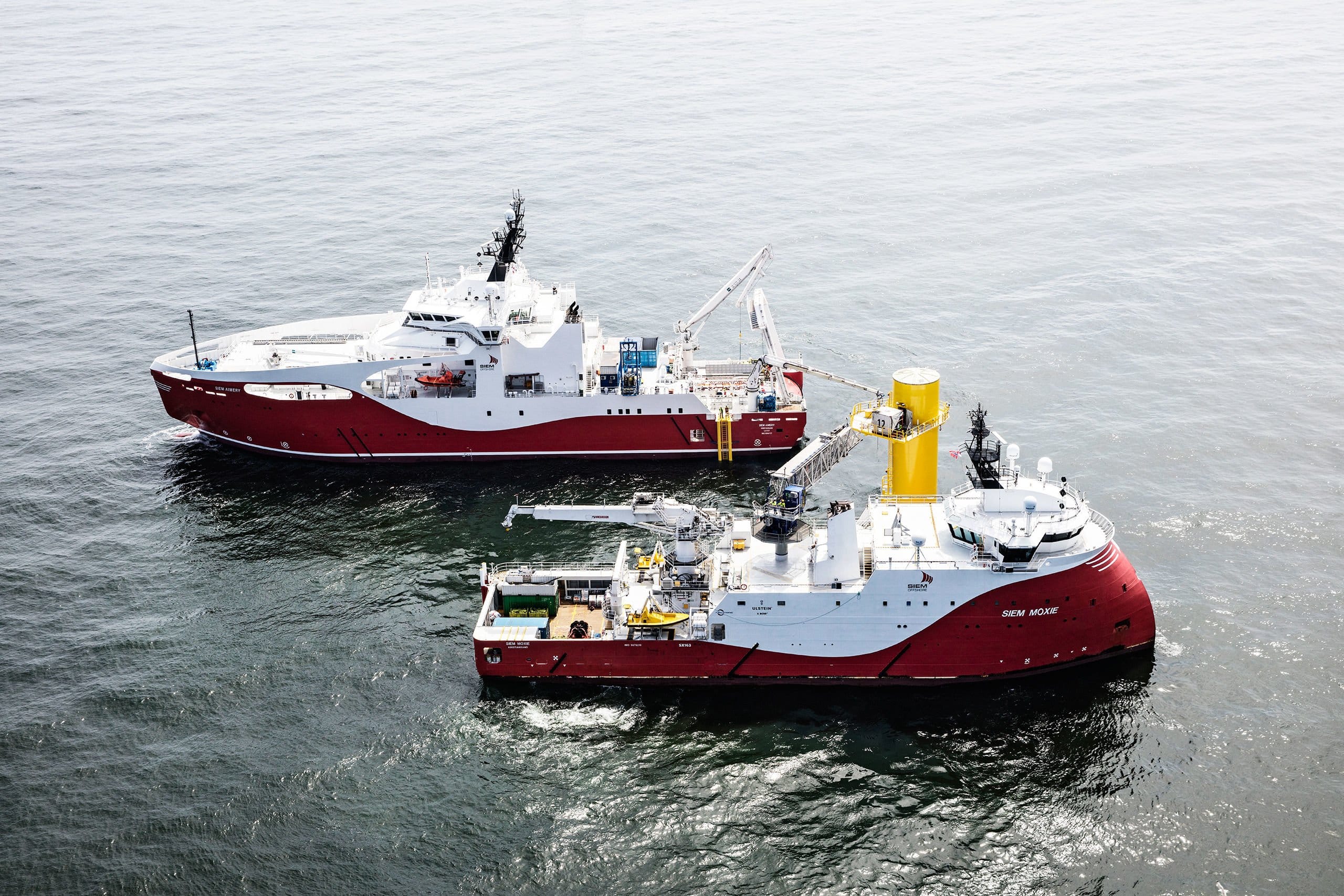 two red and white ships in the ocean